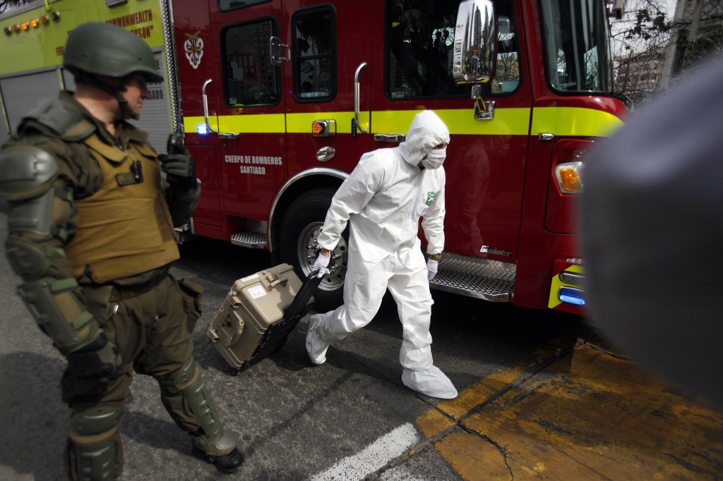Un experto forense de la policía llega al lugar donde explosionó la bomba, junto a una estacción de metro de Santiago de  Chile.© (AP foto/ Luis Hidalgo).