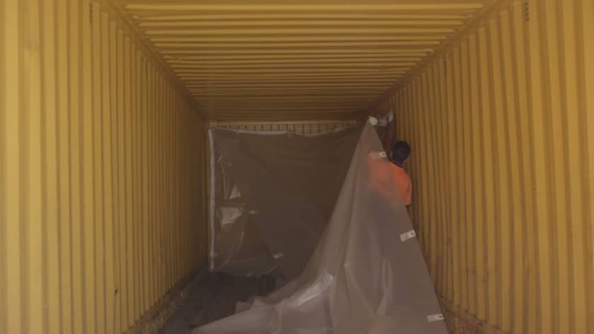 Instalación de los sacos de plástico para el transporte de maíz en el interior de los contenedores. © MITMA.