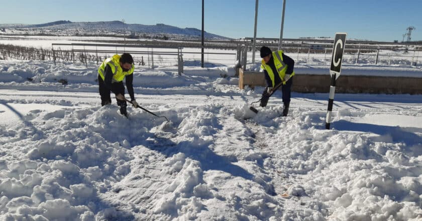 Trabajadores de Adif limpiando los andenes de una estación tras una copiosa nevada. © ADIF.