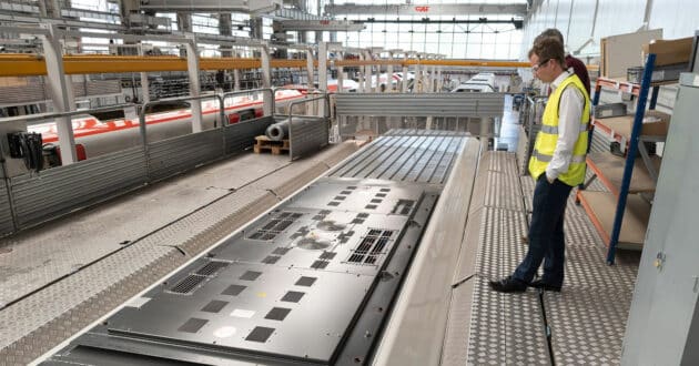 Trabajadores inspeccionando el techo de un tren en la factoría de CAF en Beasain. (CC BY SA) TOMPAGENET-Wikimedia Commons
